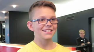 Ein Junge mit Brille und gelbem Pulli