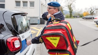 Ein Mann mit Securitas-Uniform lädt einen Defibrillator in den Kofferraum. Ein Mann mit Securitas-Uniform lädt einen Defibrillator in den Kofferraum.