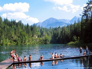 Am Crestasee in Graubünden sitzen Leute auf dem Steg. Am Crestasee in Graubünden sitzen Leute auf dem Steg.