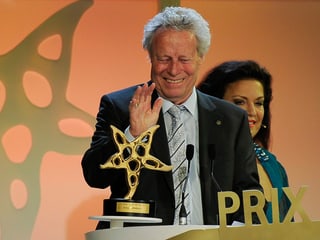 Beny Rehmann mit erhobener Hand vor dem Mikrofon und der Sternenskulptur. Beny Rehmann mit erhobener Hand vor dem Mikrofon und der Sternenskulptur.