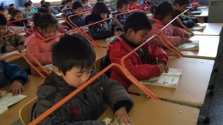 Eine chinesche Schulklasse beim Schreiben mit Metallbügeln als Distanzhalter. Eine chinesche Schulklasse beim Schreiben mit Metallbügeln als Distanzhalter.