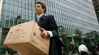 Banker, der eine Kartonschachtel trägt Banker, der eine Kartonschachtel trägt