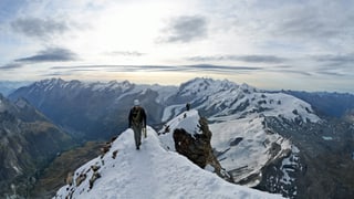 Ein Bergsteiger auf einem verschneiten Grat.