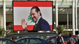 Hariri lächelt und winkt von einem Plakat in einer Strasse in Beirut.