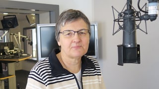 Eine Frau steht im Radiostudio vor einem Mikrophon.