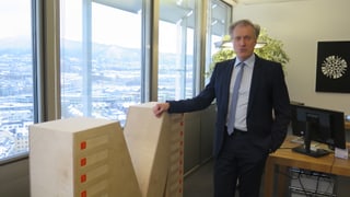 Ein Mann steht vor einem grossen M