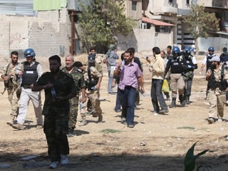 UNO-Inspektoren gehen durch das Viertel Ain Tarma in Damaskus. Sie werden von Kämpfern der Freien Syrischen Armee begleitet. (reuters)