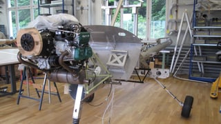 Motor und Fahrgestell eines Kleinzflugzeuges, das in einer Werkhalle zusammen gebaut wird. Motor und Fahrgestell eines Kleinzflugzeuges, das in einer Werkhalle zusammen gebaut wird.