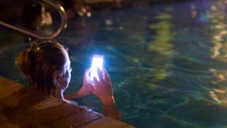 Frau mit Handy in Pool