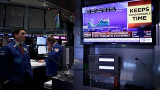 Ein Börsianer schaut einen Aktienkurs auf dem Bildschirm an. 