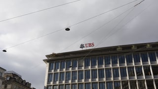 Die obersten Stockwerke einer Grossbank werden gezeigt; am Himmel sieht man die Drähte der Tramlinien. Die obersten Stockwerke einer Grossbank werden gezeigt; am Himmel sieht man die Drähte der Tramlinien.