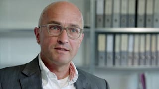 Mann mit Brille in einem Büro.