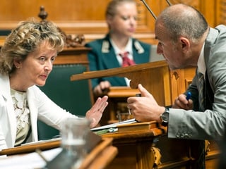 Mann spricht mit Frau im Nationalratssaal.