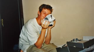 Ein Teenager küsst einen weissen Nike-Turnschuh und schaut überglücklich Ein Teenager küsst einen weissen Nike-Turnschuh und schaut überglücklich