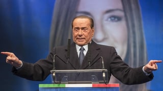 Silvio Berlusconi an einem Rednerpult.