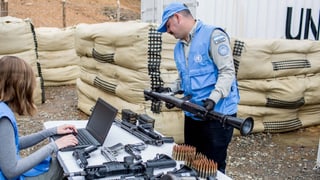 Zwei Personen in UNO-Uniformen mit Waffen.