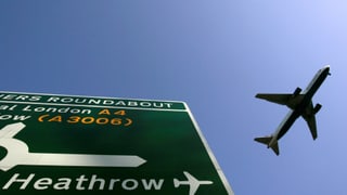 Autobahn-Tafel auf der Heathrow steht, Flugzeug in der Luft.