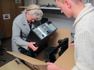 Barbara Janom hievt einen Computer aus einer Kartonschachtel