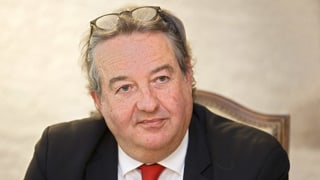 Roger Deneys mit leicht grauen Haaren und Brille auf dem Kopf. Roger Deneys mit leicht grauen Haaren und Brille auf dem Kopf.
