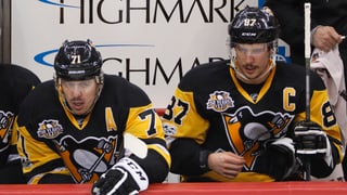 Jewgeni Malkin und Sidney Crosby sitzen auf der Spielerbank.