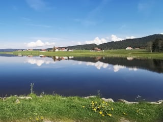 Kleine Quellwolken spiegeln sich im Wasser