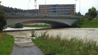 Sihl führt braunes Wasser, ein Fussweg am Ufer ist überschwemmt.