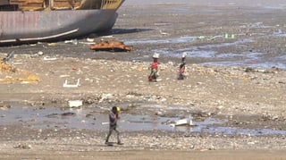 Menschen an einem verseuchten Strand. Zwei Frauen tragen Saris. Menschen an einem verseuchten Strand. Zwei Frauen tragen Saris.