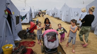 Kinder und Frauen in einem Zeltlager.