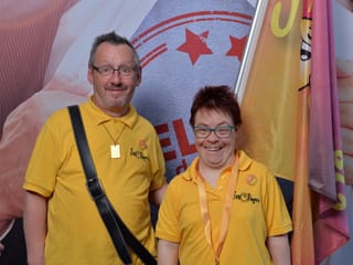 Zwei «Sun Singers» posieren mit Fahne.