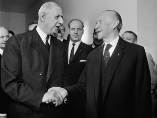Charles De Gaulle (l) und Konrad Adenauer (r), sich gegenseitig die Hände drückend