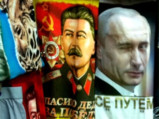 T-Shirt-Auslage an einem Kiosk: links Putin-MOtiv auf rotem Hintergund, rechts Putin.