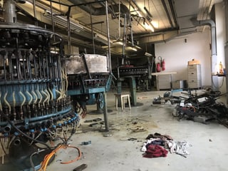 Alte museumsreife Maschinen in einer halbleeren Fabrikhalle. 