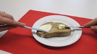 Ein Stück Brot mit Butter und mit Margarine bestrichen
