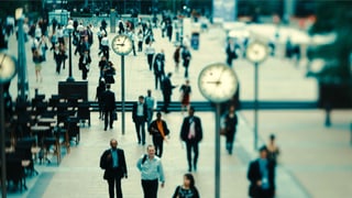 Passanten in London, alle paar Meter steht eine Uhr.