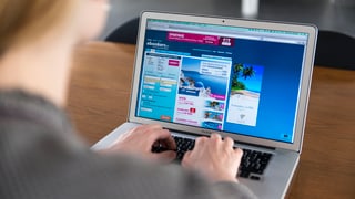 Blick über die Schulter einer Frau auf den Bildschirm eines Laptops auf einem Tisch. Blick über die Schulter einer Frau auf den Bildschirm eines Laptops auf einem Tisch.