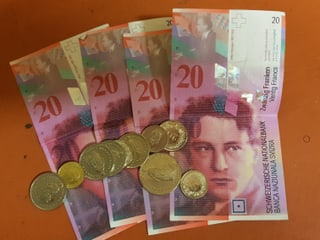 Vier 20er-Noten und Münzen.
