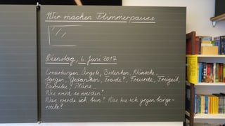 Wandtafel in einem Schulzimmer - eine Hälfte ist beschriftet. Wandtafel in einem Schulzimmer - eine Hälfte ist beschriftet.