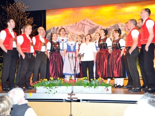 Sänger und Sängerinnen eines Jodelchors im Halbkreis auf einer Bühne.