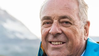 Kopf von Alt Bundesrat Adolf Ogi, er lächelt in Kamera, im Hintergrund eine Bergflanke. Kopf von Alt Bundesrat Adolf Ogi, er lächelt in Kamera, im Hintergrund eine Bergflanke.