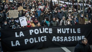 Demonstranten tragen ein Banner. Darauf steht auf Französische: Die Polizei mutiliert, die Polizei mordet. Demonstranten tragen ein Banner. Darauf steht auf Französische: Die Polizei mutiliert, die Polizei mordet.