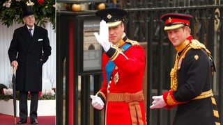 Prinz Philip steht im Frack vor einem Gebäude. William und Harry winken.