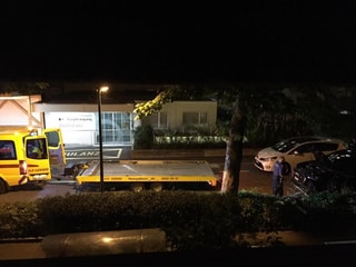 Die Polizei transportiert mit einem gelben Abschleppwagen ein schwarzes Auto ab. Es ist Nacht. Die Polizei transportiert mit einem gelben Abschleppwagen ein schwarzes Auto ab. Es ist Nacht.