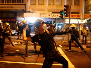 Demonstrant wirft Stein