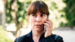 Eine Frau hält ein Telefon ans Ohr.