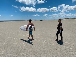 Ein Mann mit einem Surfboard am Strand. Ein Mann mit einem Surfboard am Strand.