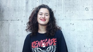 Eine junge Frau vor einer Betonwand. Eine junge Frau vor einer Betonwand.
