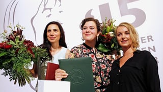 Die drei stehen in einer Reihe mit Bluemnsträussen.