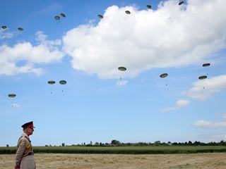 Prinz Charles in Ranville, Normandie. Im Hintergrund: Fallschirmspringer 