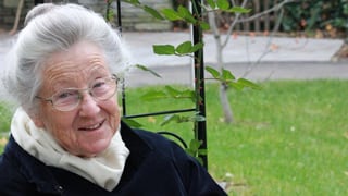 Margrit Reithaar auf Parkbank sitzend draussen im Grünen.