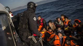 Frontex-Mitglied empfängt Bootsflüchtlinge.